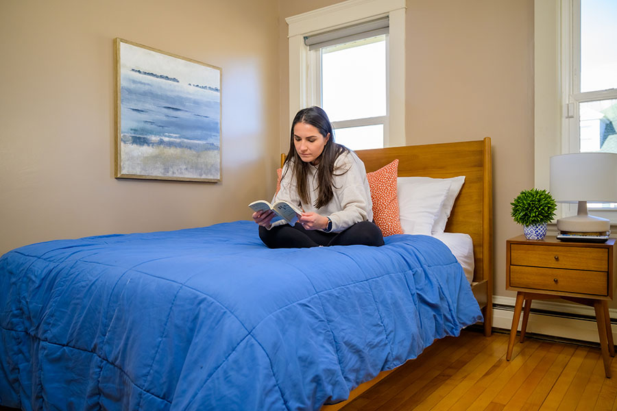 a woman sitting on a comfortable bed